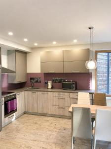 a kitchen with a wooden table and a dining room at Klaipeda Seaside Apartments with self check-in in Klaipėda