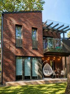 a brick house with a balcony and a swing at Klaipeda Seaside Apartments with self check-in in Klaipėda