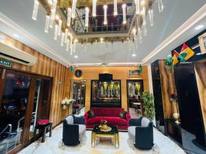 a living room with a red couch and chairs at HOTEL MADNI ROYALE (50 Mtrs from Dargaah), Ajmer in Ajmer