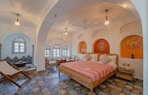 a bedroom with a bed and a table and chairs at Sitaram Bhawan - A 250-Year- Old Heritage Haveli, Jaipur in Jaipur