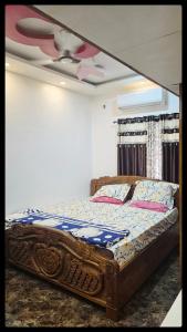 a bed in a room with a ceiling fan at Lucky garden inn in Chennai