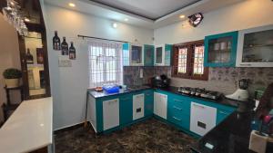a kitchen with blue cabinets and a counter top at Lucky garden inn in Chennai