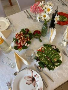 a table with plates of food and flowers on it at Zameczek in Mikołajki +15 photos