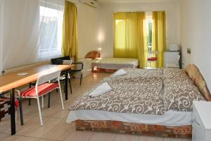 a bedroom with a bed and a desk and a table at Klassz Apartmanház in Balatonfüred