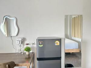 eine Küche mit Kühlschrank, Tisch und Bett in der Unterkunft Comfy hotels คอมฟี่โฮเทล in Suvarnabhumi Airport