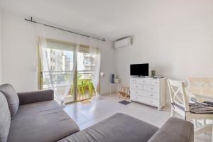 a living room with a couch and a tv at Resguardo en la playa in Calafell