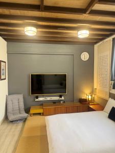 a bedroom with a bed and a tv on a wall at 海軍官邸眷村民宿 in Nan-men