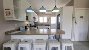 a kitchen with a counter and four stools in it at Sue Casa 3 in Margate