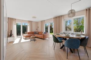 a living room with a table and chairs and a couch at Mosselbank 073 - Noordzeepark Ouddorp in Ouddorp