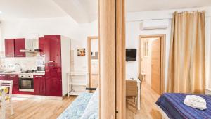 a small apartment with red cabinets and a kitchen at casa del sole in Taormina