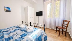 a bedroom with a bed and a chair and a window at casa del sole in Taormina