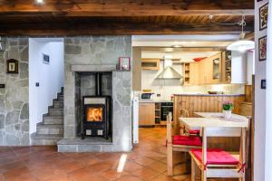 a kitchen with a stone fireplace in the middle of a room at Albatros in Bovec