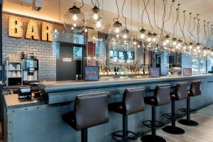 a bar with bar stools in a restaurant at Premier Inn Berlin Alexanderplatz in Berlin