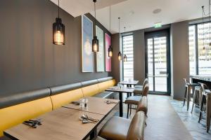 a dining room with tables and chairs and lights at Premier Inn Berlin Alexanderplatz in Berlin