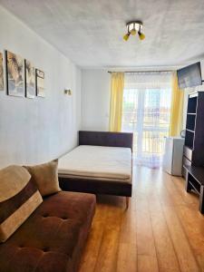a living room with a bed and a couch at U Piotra in Sarbinowo