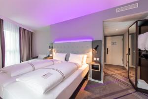 a hotel room with two beds and a purple ceiling at Premier Inn Stuttgart Feuerbach in Stuttgart