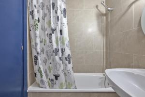 a bathroom with a shower curtain with a toilet and a sink at Resguardo en la playa in Calafell +12 photos