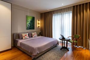 a bedroom with a bed and a desk and a window at Well-being Home - Self-Service in Hanoi