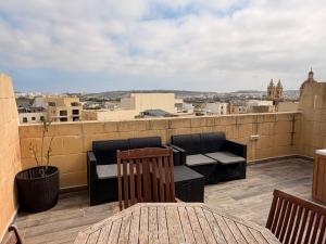 a balcony with furniture and a view of a city at De Rock Penthouse in Sannat