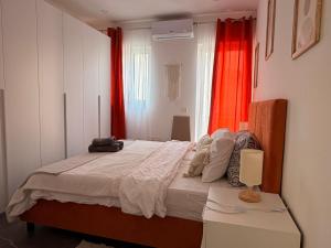 a bedroom with a large bed with a red curtain at De Rock Penthouse in Sannat
