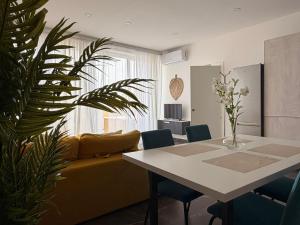 a living room with a table and a yellow couch at De Rock Penthouse in Sannat