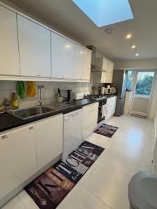 a kitchen with white cabinets and a sink at London Heathrow Uxbridge Escape in Uxbridge
