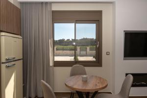 a kitchen with a table and chairs and a window at Antaia 1 in Nafplio