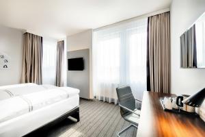a hotel room with a bed and a desk and chair at Premier Inn München City Ost in Munich