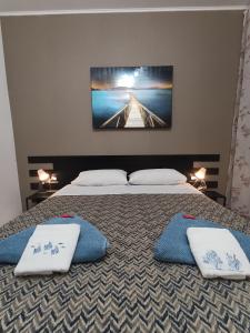 a bedroom with two beds with pillows and a tv on the wall at Rolando 20B in Genoa