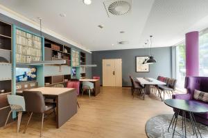 a dining room with tables and chairs and purple walls at Premier Inn Berlin City Centre in Berlin