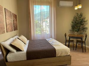 a bedroom with a bed with a window and a table at Affittacamere Yara 5 Terre in La Spezia