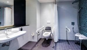 a bathroom with a toilet and a sink at Premier Inn München Airport Süd in Hallbergmoos +16 photos