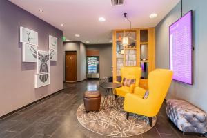 a lobby with yellow chairs and a table at Premier Inn Stuttgart Airport Messe in Leinfelden-Echterdingen