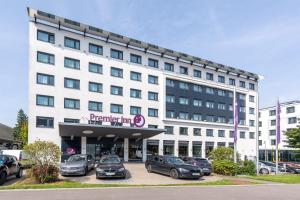 a large white building with cars parked in a parking lot at Premier Inn Stuttgart Airport Messe in Leinfelden-Echterdingen