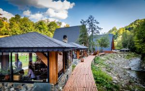a building with a wooden walkway next to a river at CABANELE IULI'S HOME in Runcu