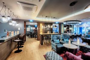 a restaurant with tables and chairs and a bar at Premier Inn Berlin City Süd in Berlin