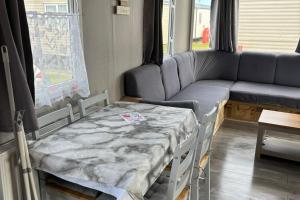 a hospital room with a table and a couch at 6Berth Caravan-Wheelchair Accessible-Pet Friendly in Skegness