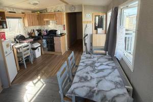 a kitchen with a table and chairs in a room at 6Berth Caravan-Wheelchair Accessible-Pet Friendly in Skegness