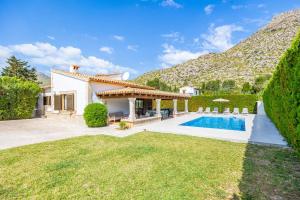 a villa with a swimming pool in front of a mountain at Villa Cal Peso in Port de Pollensa