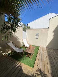 a patio with two chairs and a table on a deck at Maison de vacances, centre ville Gambetta in La Teste-de-Buch