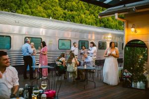 a bride and groom standing in front of a train at The Historic Railway Barracks in Goulburn