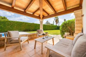 a patio with a couch and chairs and a table at Villa Cal Peso in Port de Pollensa