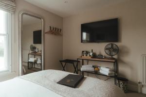 a bedroom with a bed and a television on the wall at Winemaker's Pub in Goudhurst