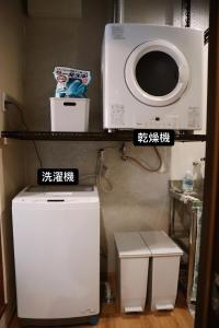 a microwave and a washer and dryer in a room at Guest House BLUE DOOR in Imabari Railway Station