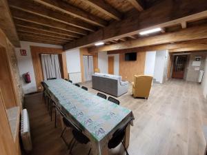 a large room with a long table and a couch at Alojamiento Turístico Río Uces in La Zarza de Pumareda