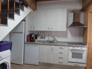 a kitchen with white cabinets and a sink at Alojamiento Turístico Río Uces in La Zarza de Pumareda