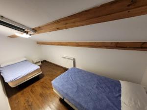 a bedroom with two beds in a room with wooden floors at Alojamiento Turístico Río Uces in La Zarza de Pumareda +17 photos