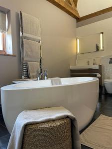 a bathroom with a large white tub and a sink at The Silver Suite at Manor Farm in Edenbridge