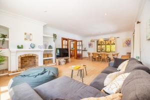a living room with a couch and a fireplace at Villa Cal Peso in Port de Pollensa