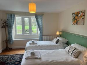 a hotel room with two beds and a window at Castle Lodge Haughton Castle in Hexham